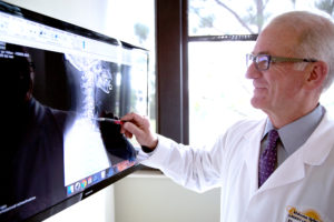 Dr. Odor reviewing a spinal x-ray on computer monitor.